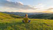woman meditating on hill at sunset peaceful nature landscape (Person stock photos by Vecteezy.com)