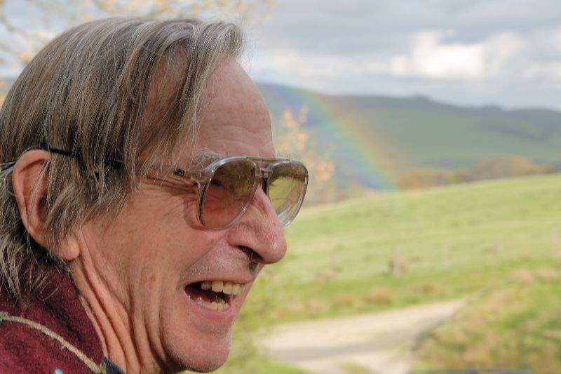 John Crook, laughing, with a rainbow behind him