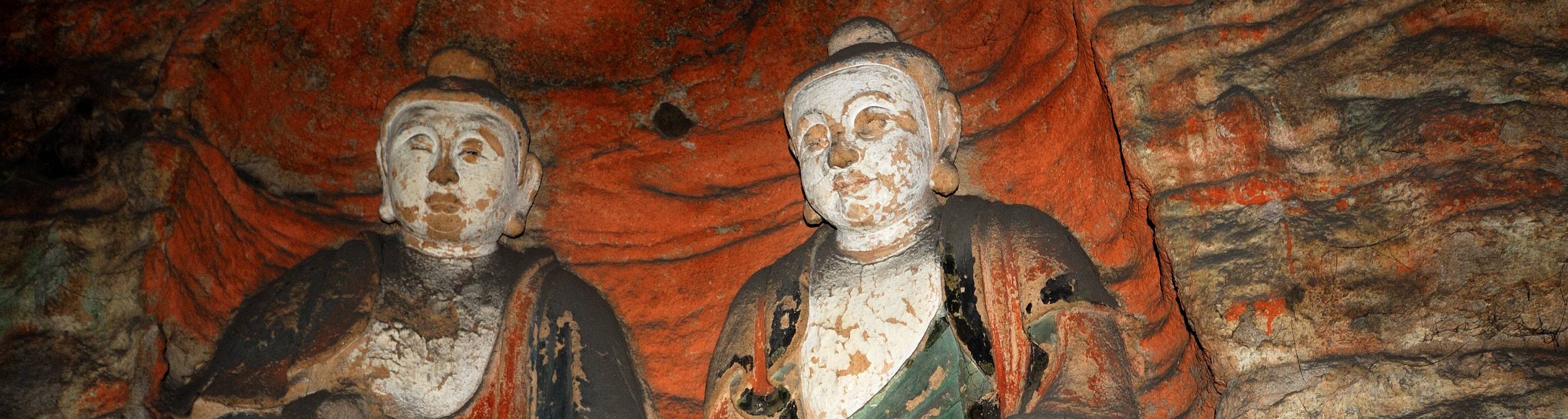 two very large seated stone buddhist statues in one of the caves at yungang grottoes